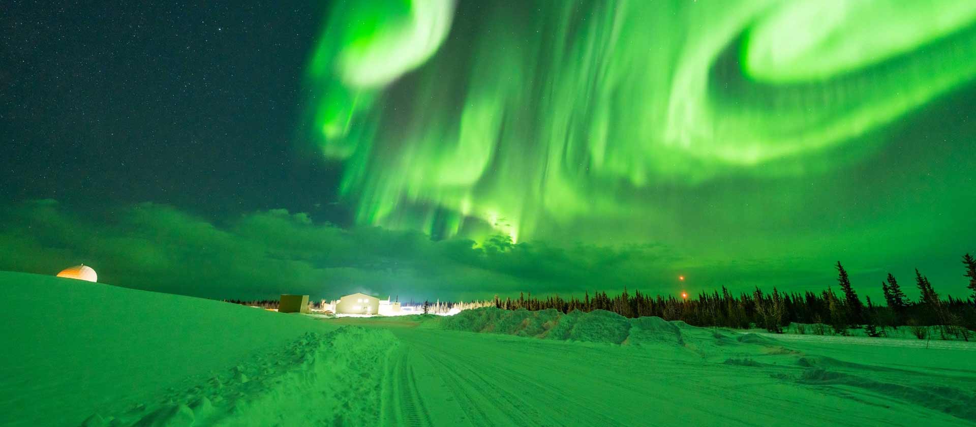 paysage d'une nuit enneigé du Yukon. Le ciel clair fait découvrir de magnifiques et incroyables aurores boréales