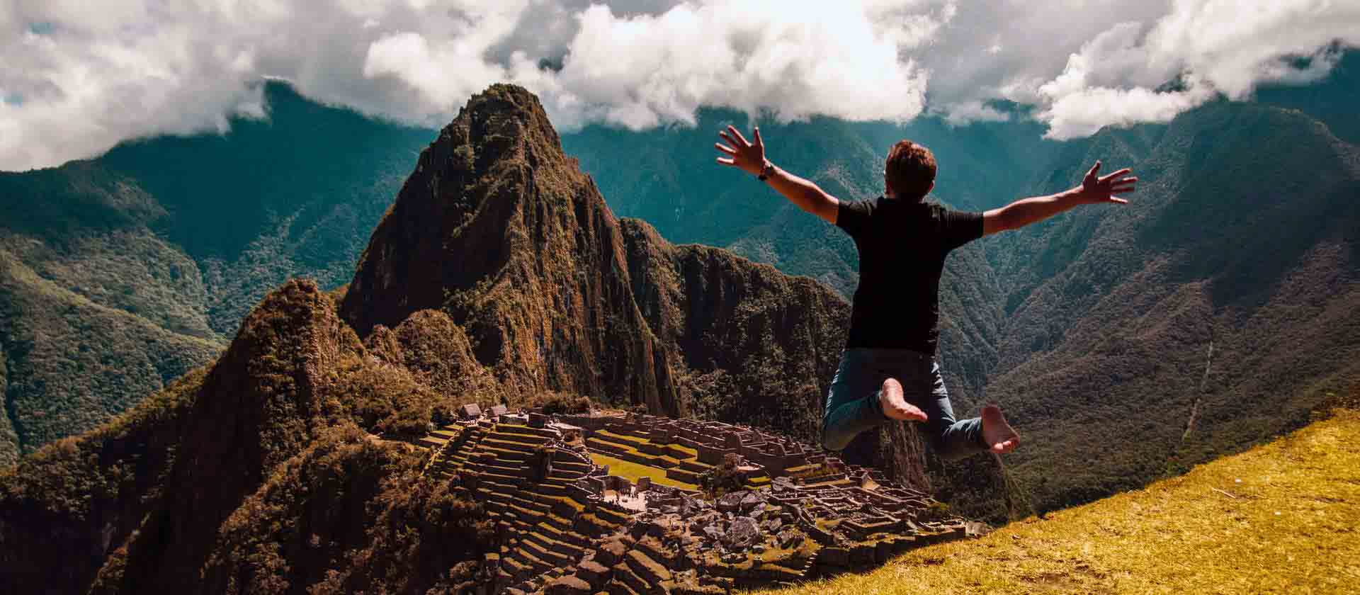 Un homme saute de joie devant la magnifique vue des montagnes du Pérou